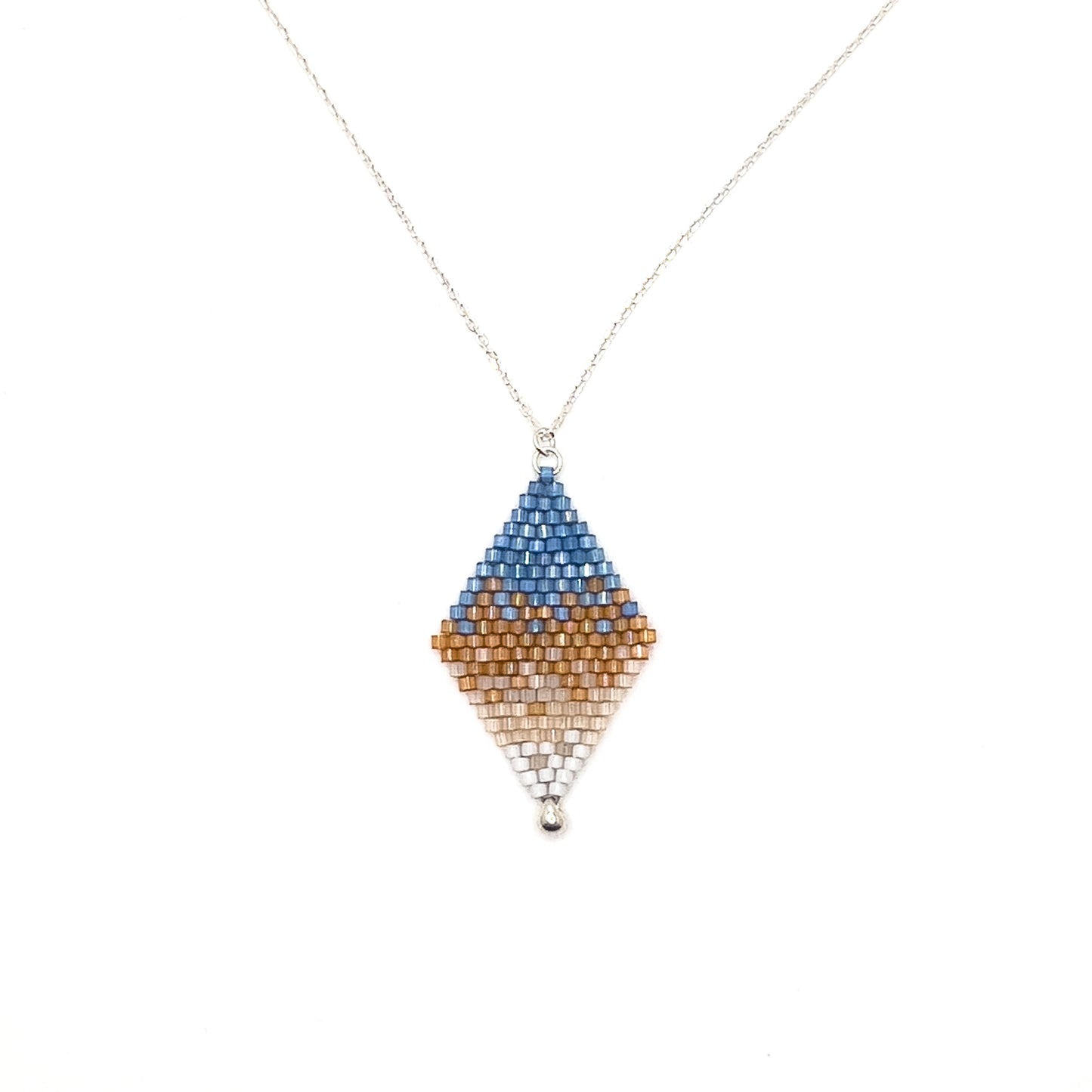 Handcrafted beaded pendant with a sterling silver chain inspired by the Eastern Bluebird, featuring a gradient pattern with blue, amber, and white beads laying on a white background.
